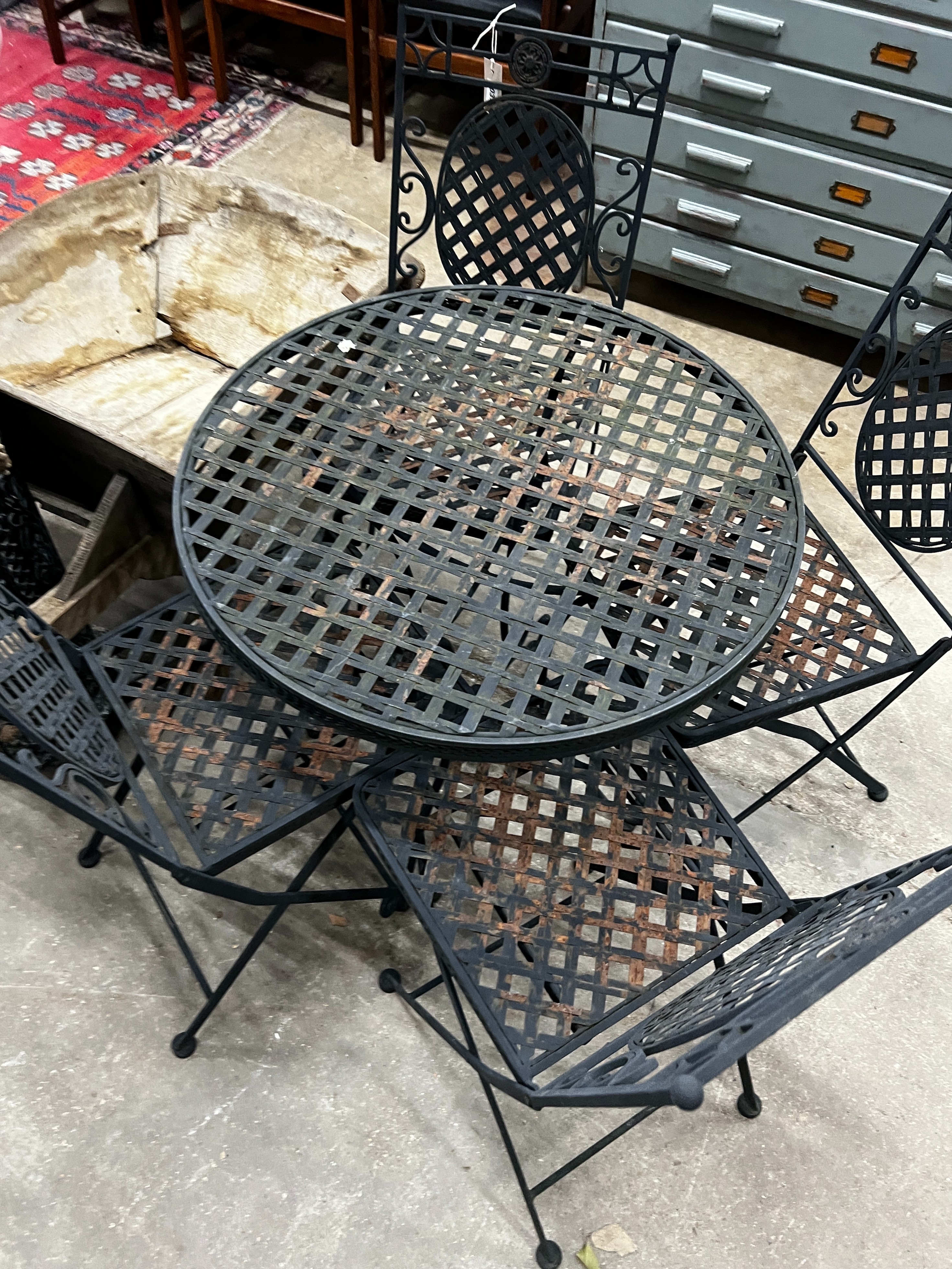 A circular painted metal garden table, diameter 70cm, height 71cm together with four matching folding garden chairs